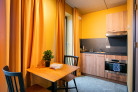 Keuken met oven, magnetron en kookplaat en tweepersoons tafel in de Deluxe Studio van Hotel Marktstad.