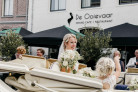 Bruid geniet met kind van haar bruiloft bij Hotel Marktstad.